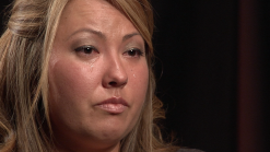 A close up of a woman 's face with tears running down her face.
