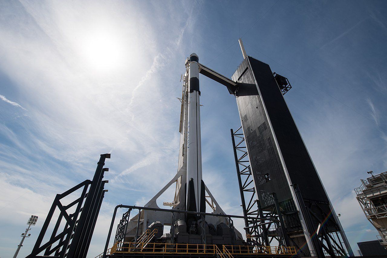 A large rocket is sitting on top of a large building.