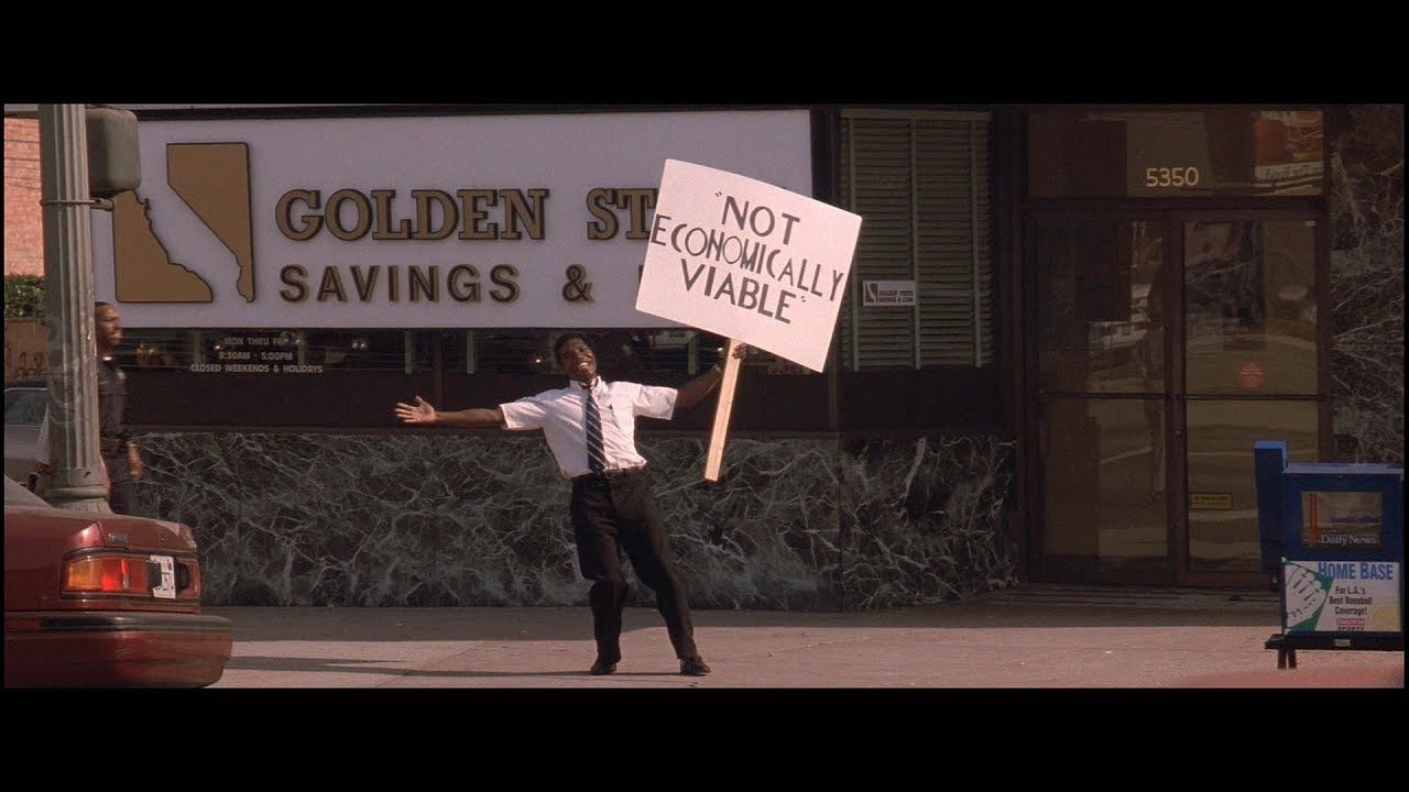 A man is holding a sign that says not economically viable