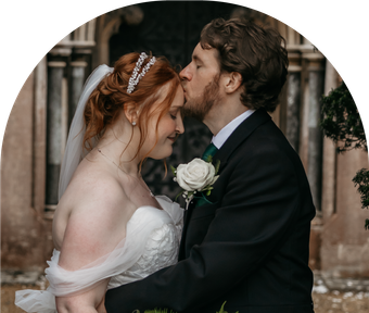 A bride and groom kissing in front of a building