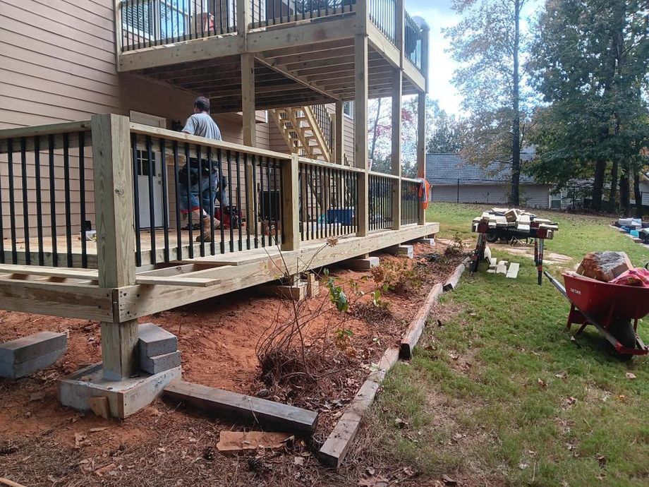 A wooden deck is being built in the backyard of a house.