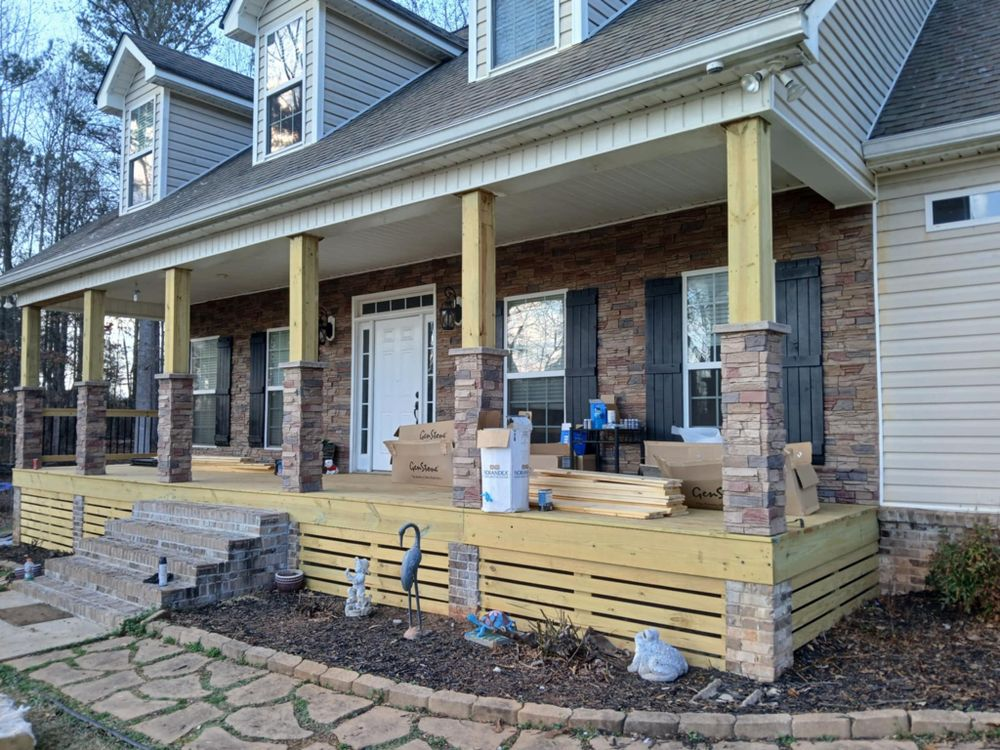 A large brick house with a wooden porch under construction.