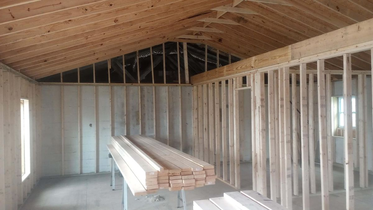 A room with a lot of wooden beams and a ceiling.