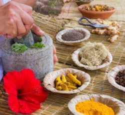 A person is using a mortar and pestle to grind spices on a table.