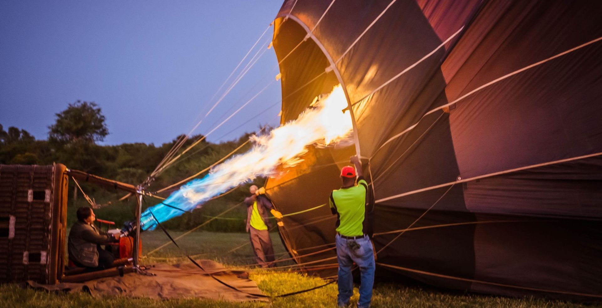 a man is lighting a hot air balloon with a torch .