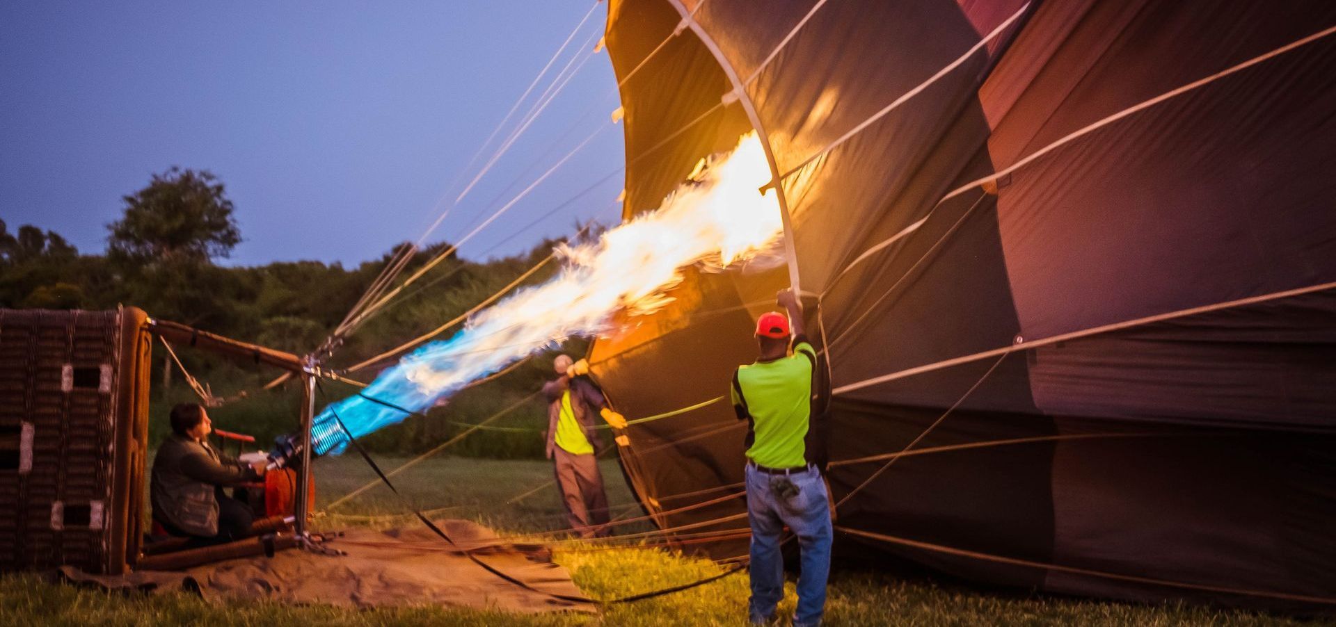 a man is lighting a hot air balloon with a torch .