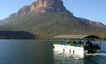 A boat is floating on a lake with a mountain in the background