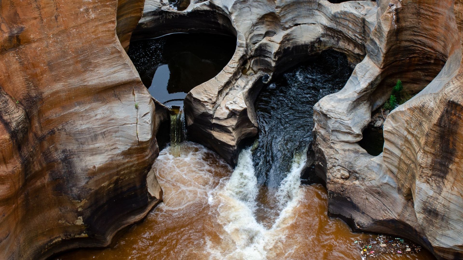 A waterfall is coming out of a hole in the rocks.