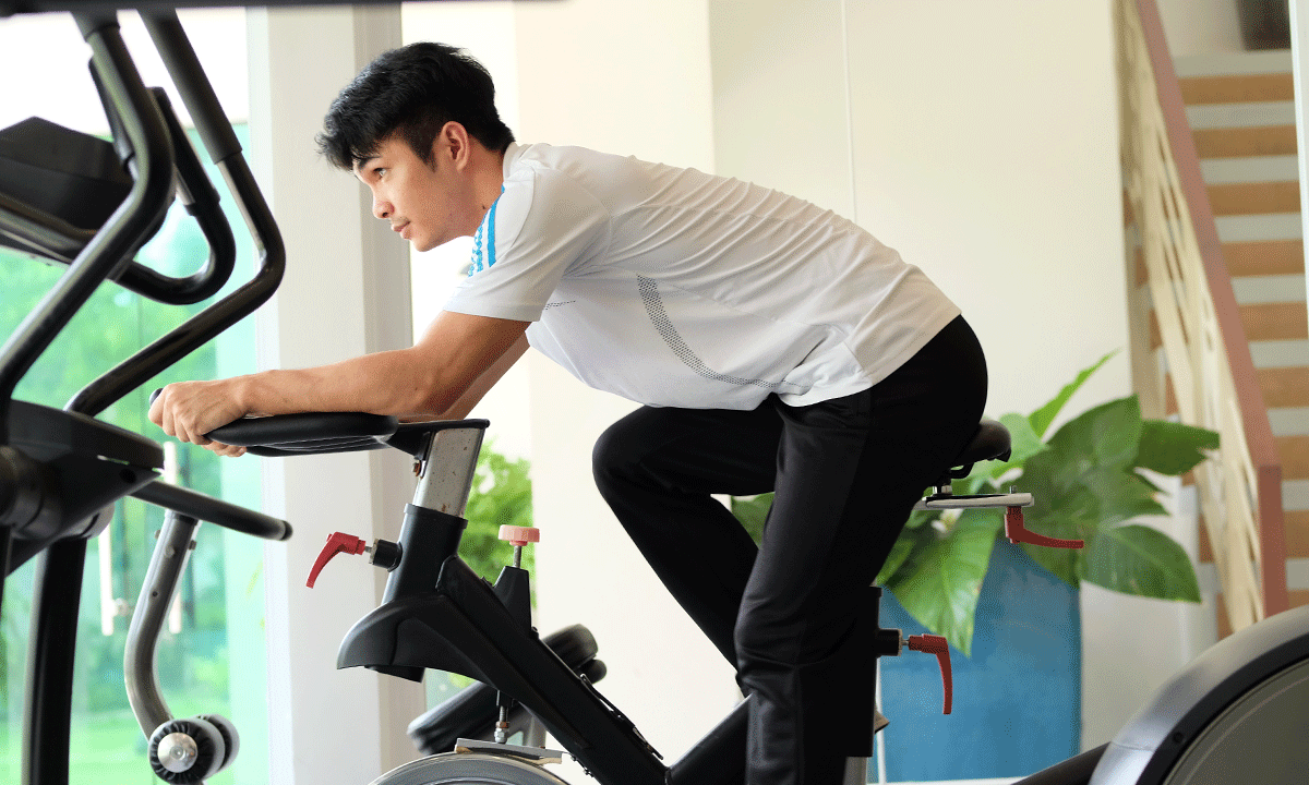 A guest using the modern fitness center at Harvest Hotel, a key wellness amenity for those seeking quality business accommodation.
