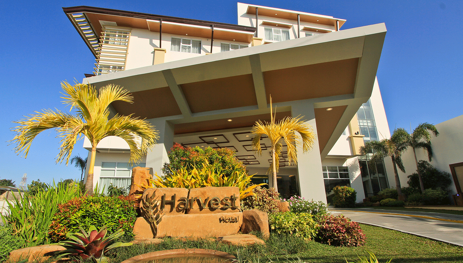 Harvest Hotel exterior with tropical gardens in Cabanatuan City Philippines