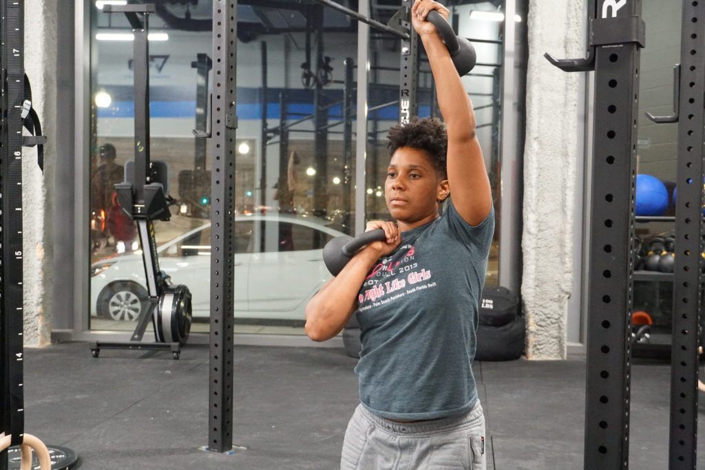Athlete performing a mixed rack kettlebell carry
