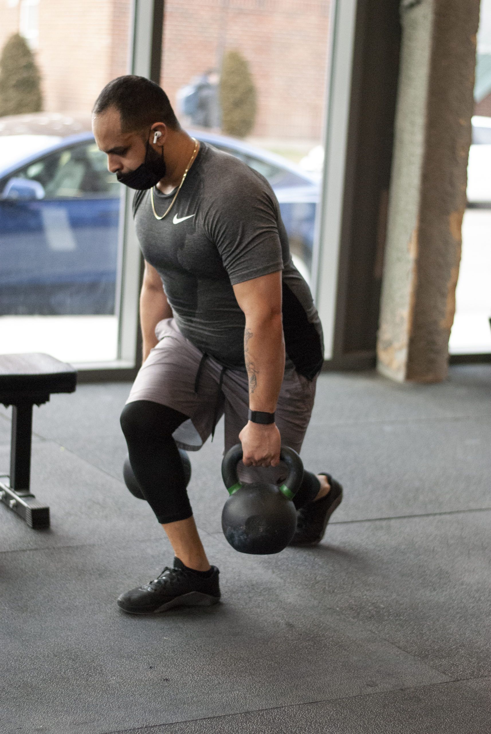 Coach Joel lunging with kettlebells