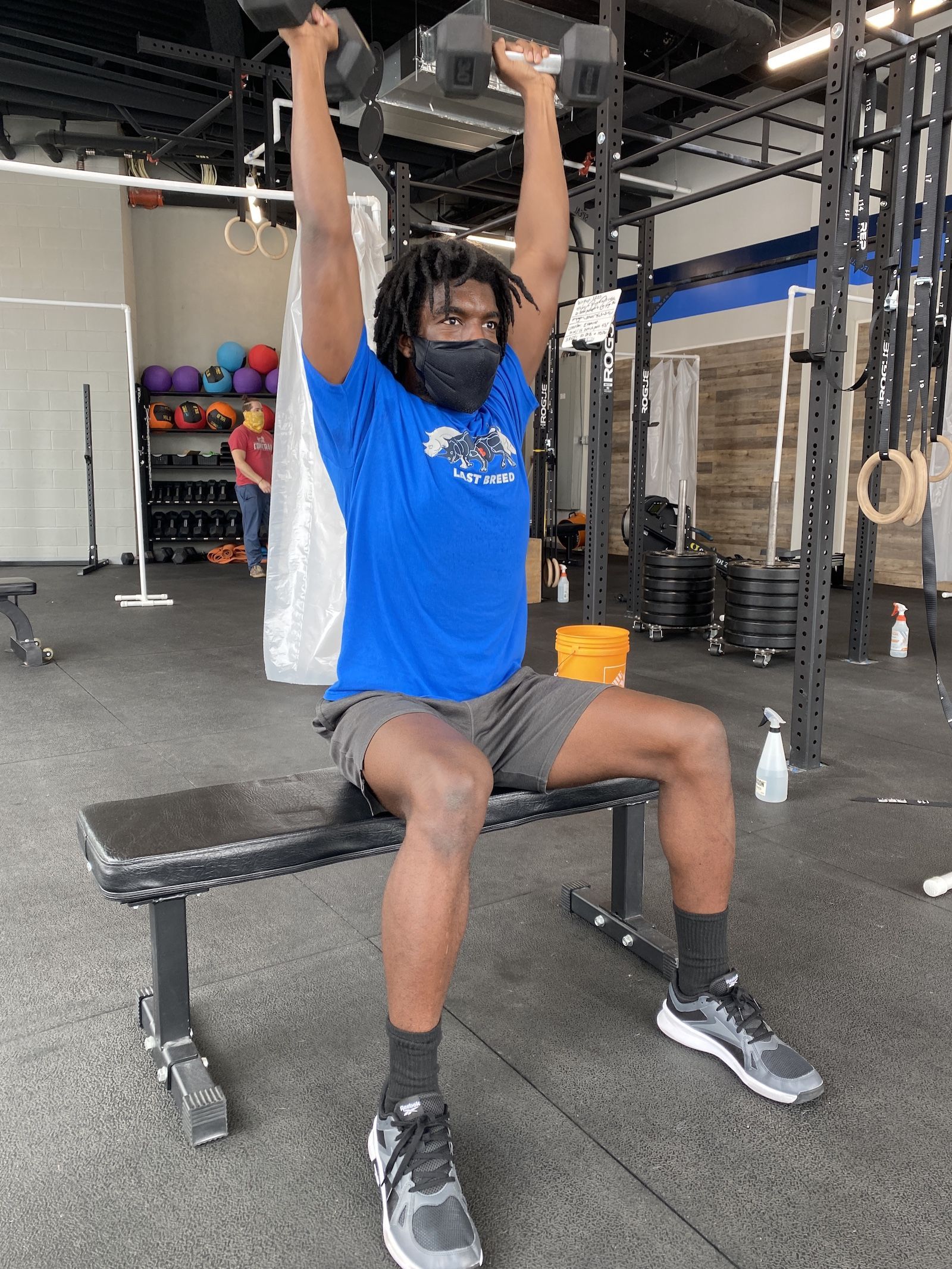 Athlete performing a seated dumbbell strict press.