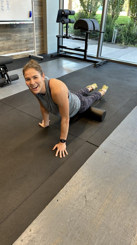 A member laughing while using a foam roller