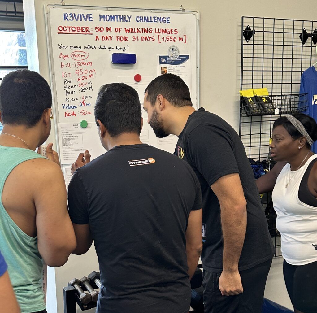 A group of athletes huddled around the posted workout events.