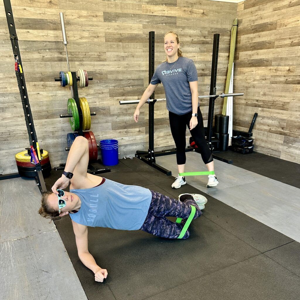 Two athletes performing a warm up using resistance bands.