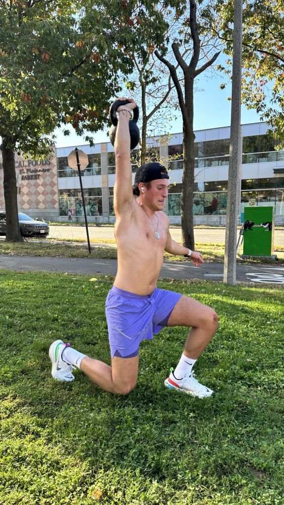 A member performing an overhead walking lunge.