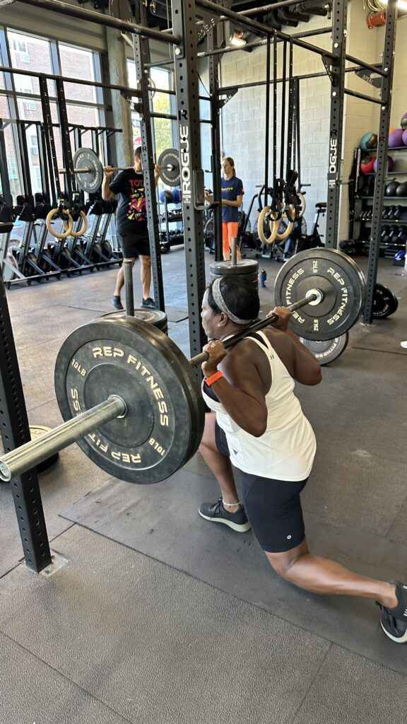 A member performing a backwards lunge using a barbell as part of the second event of our throw down.