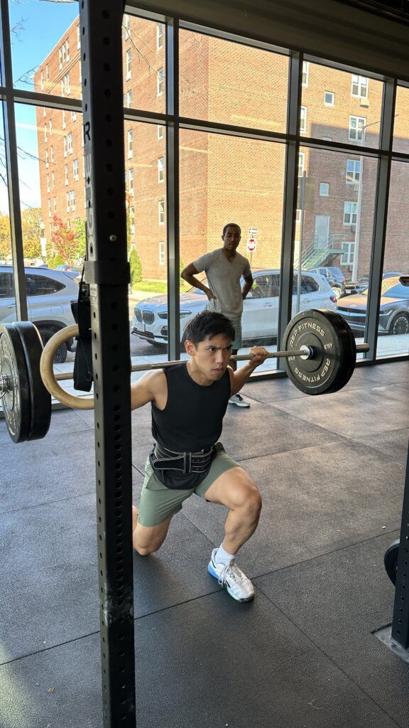 A member performing a step back lunge with an intense look on his face.
