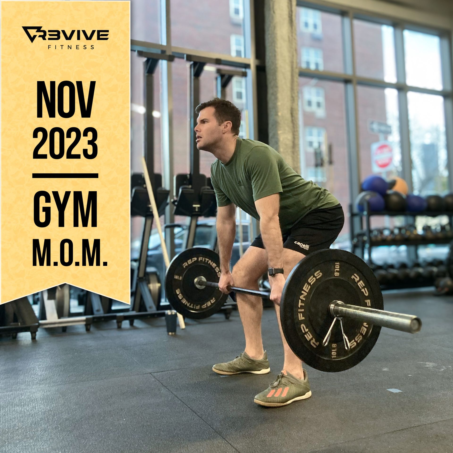 Man deadlifting at a gym, November 2023. He wears green shirt, black shorts, and grey shoes. Gym equipment in background.