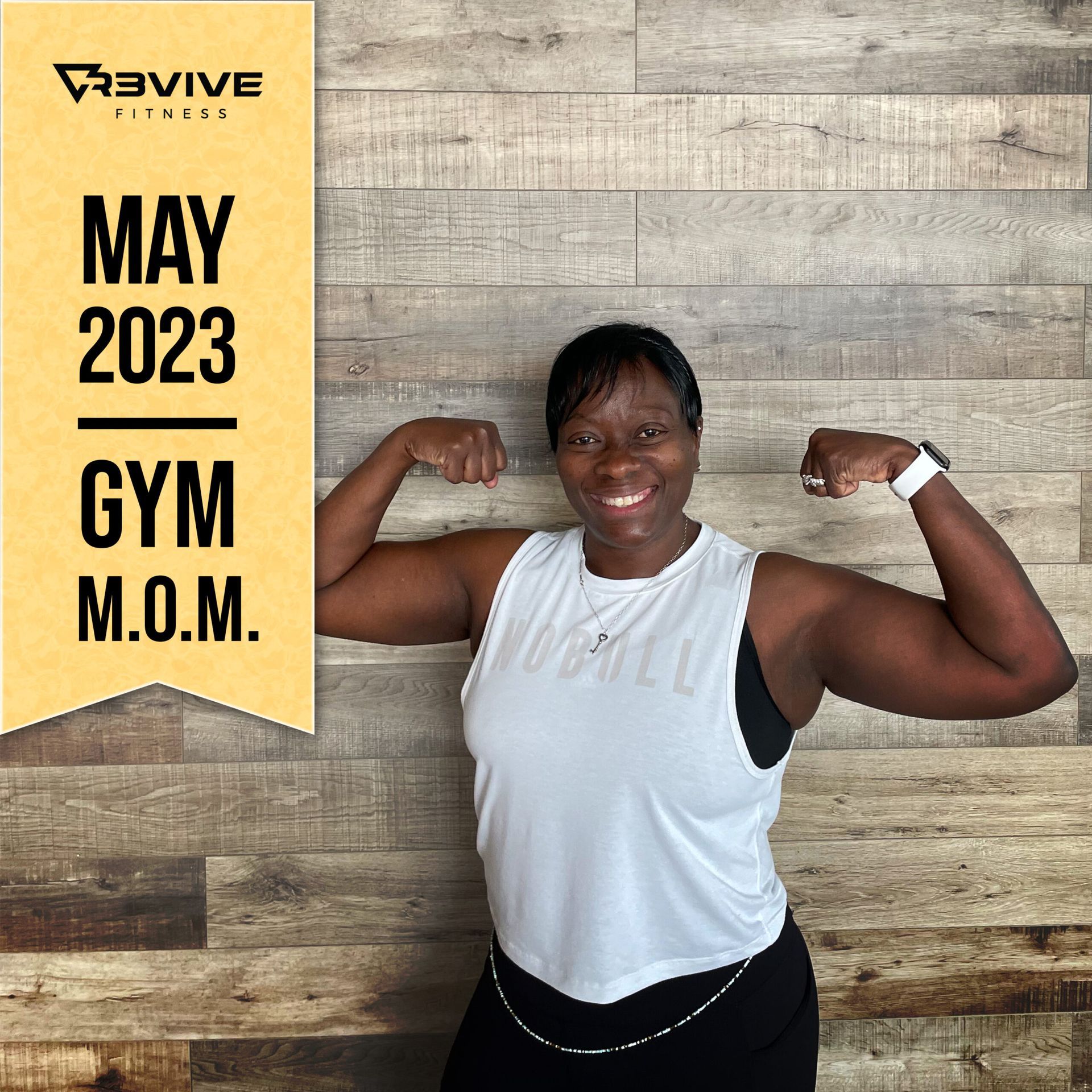 Woman flexes, smiling, in gym attire, May 2023 Gym Mom for Revive Fitness, against a wood backdrop.