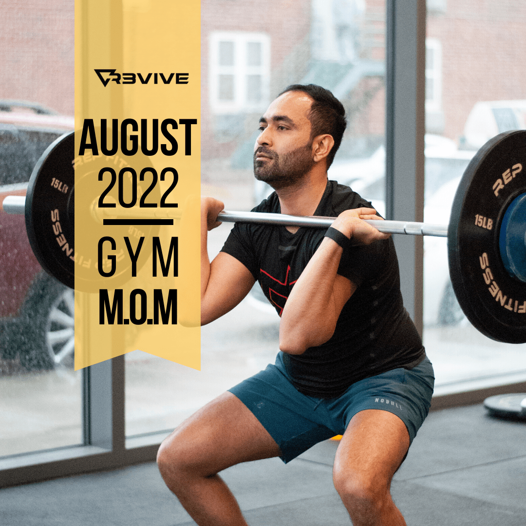 Man doing a barbell squat in a gym. August 2022
