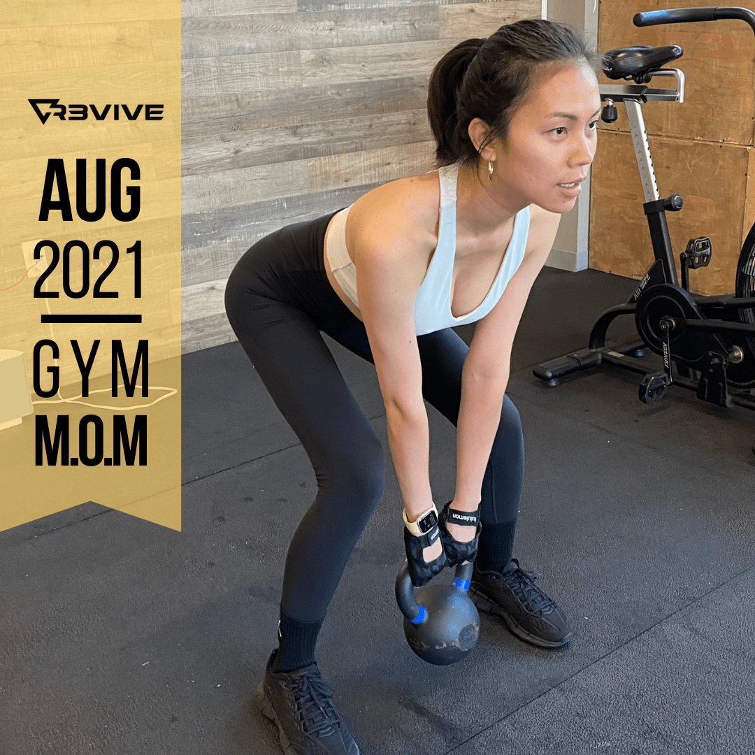Woman in gym attire lifts a kettlebell. Gym setting, focused expression.