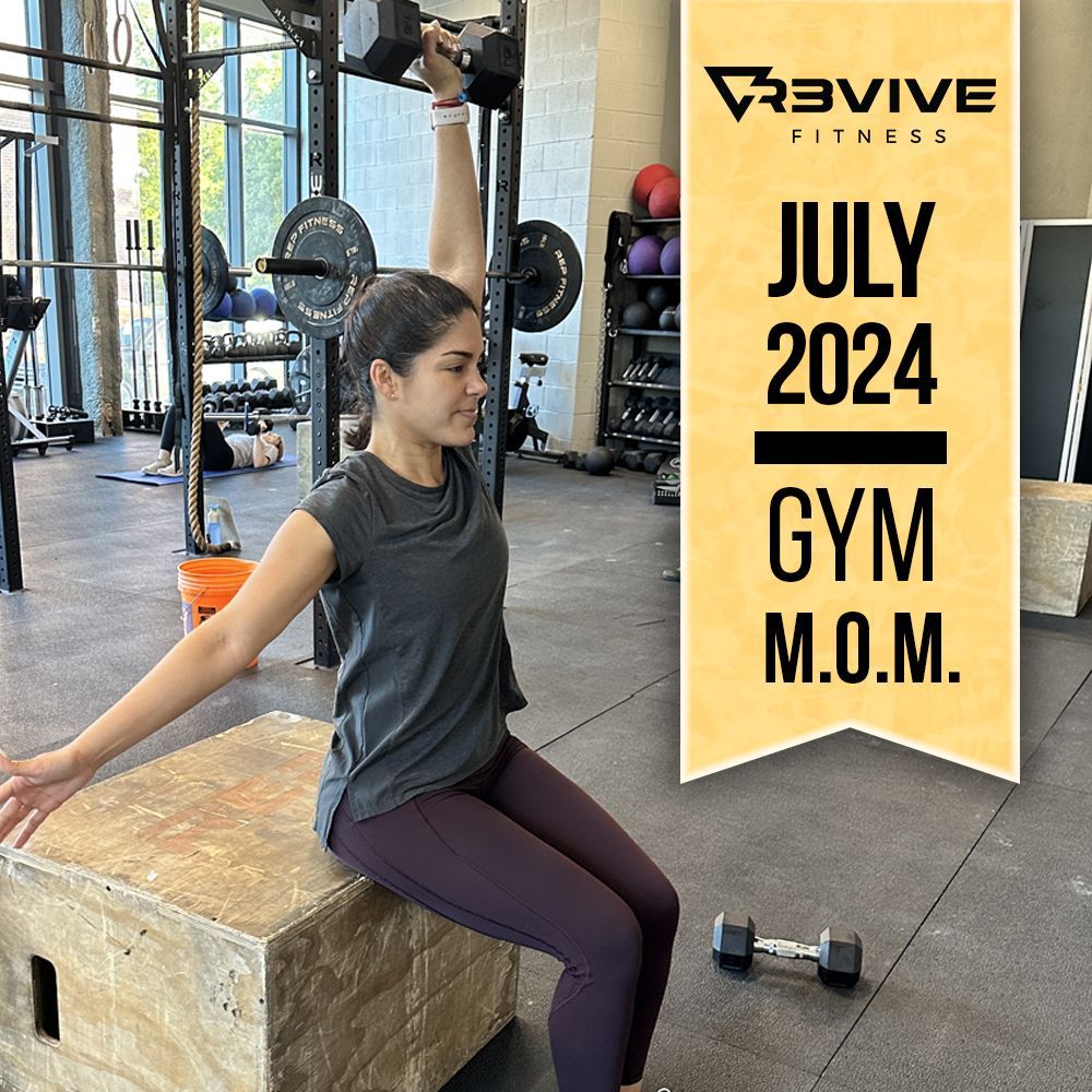 Woman lifting dumbbell in gym, seated on a box, with