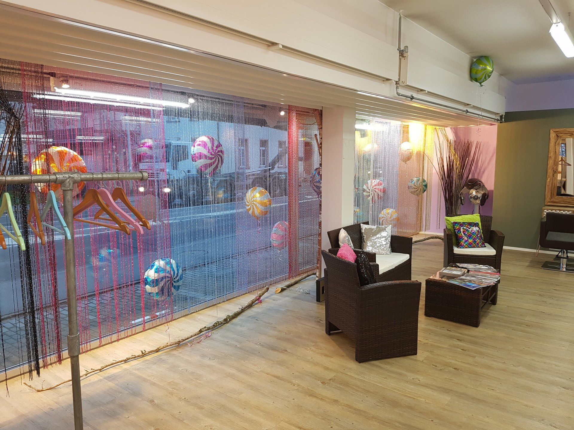 Ein Zimmer mit einem Sofa, einem Sessel, einem Tisch und Luftballons an der Wand.