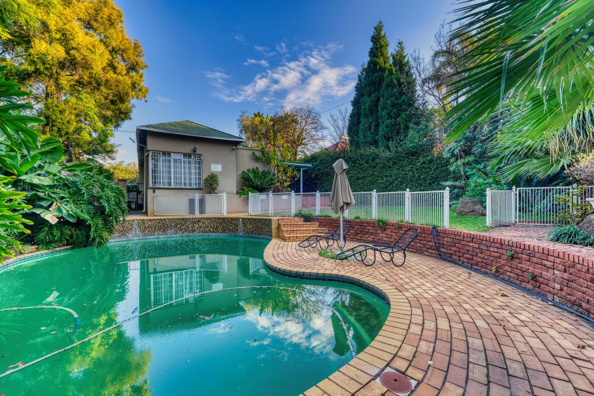 Stainless steel railings elegantly frame the pristine pool, creating a modern and sophisticated contrast.