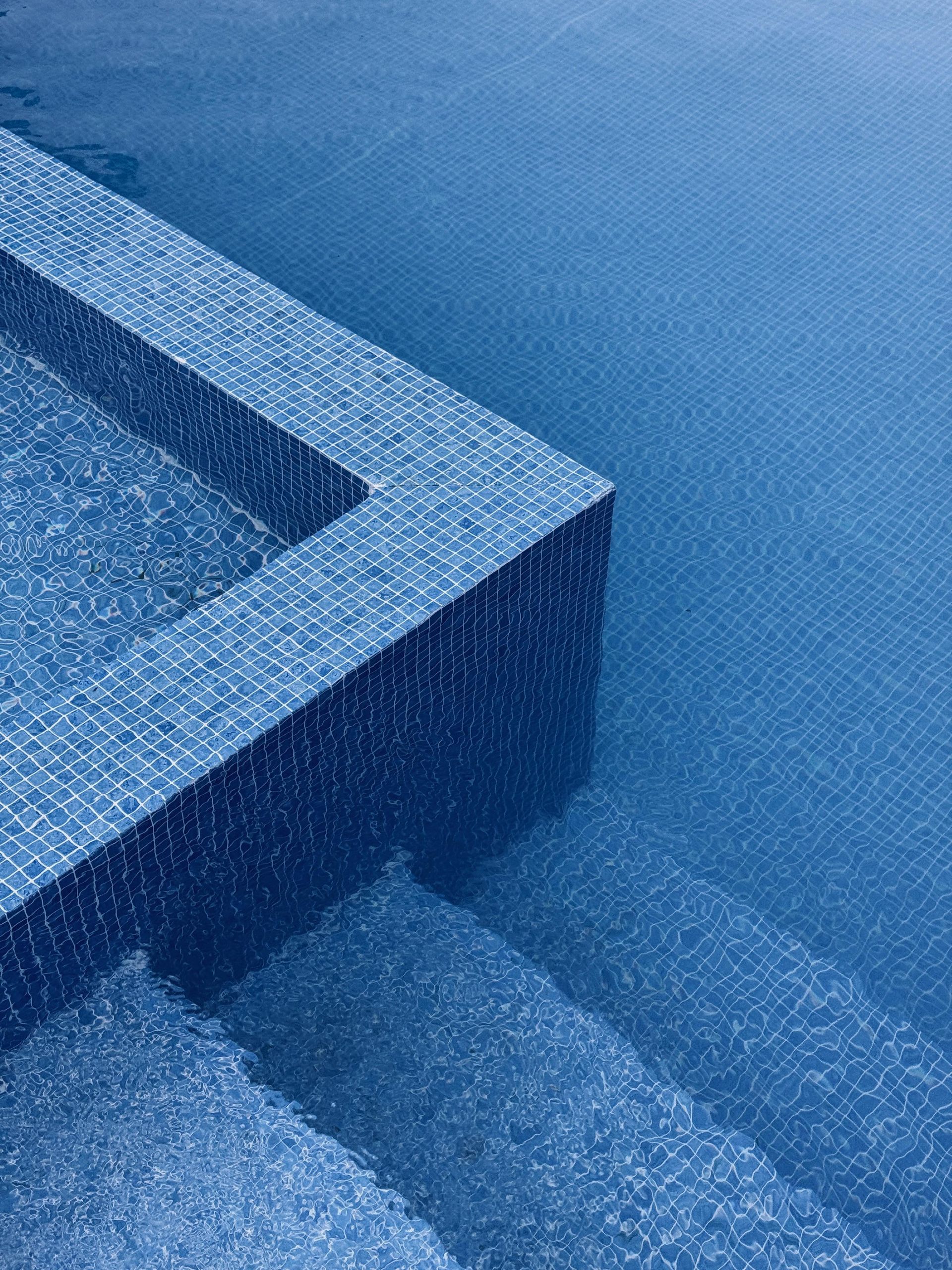 Stainless steel railings elegantly frame the pristine pool, creating a modern and sophisticated contrast.