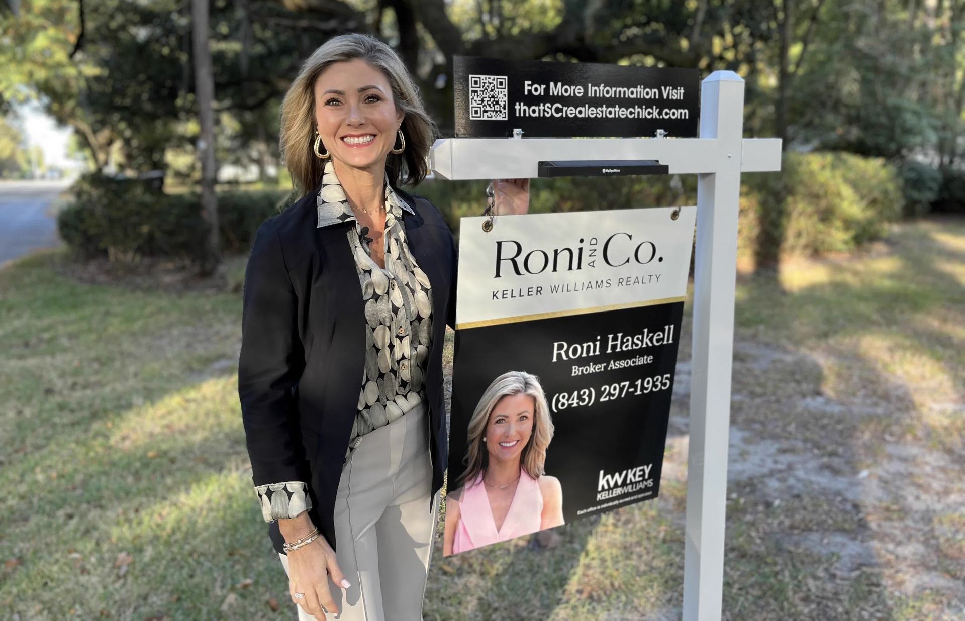 A woman is standing next to a sign that says roni co.