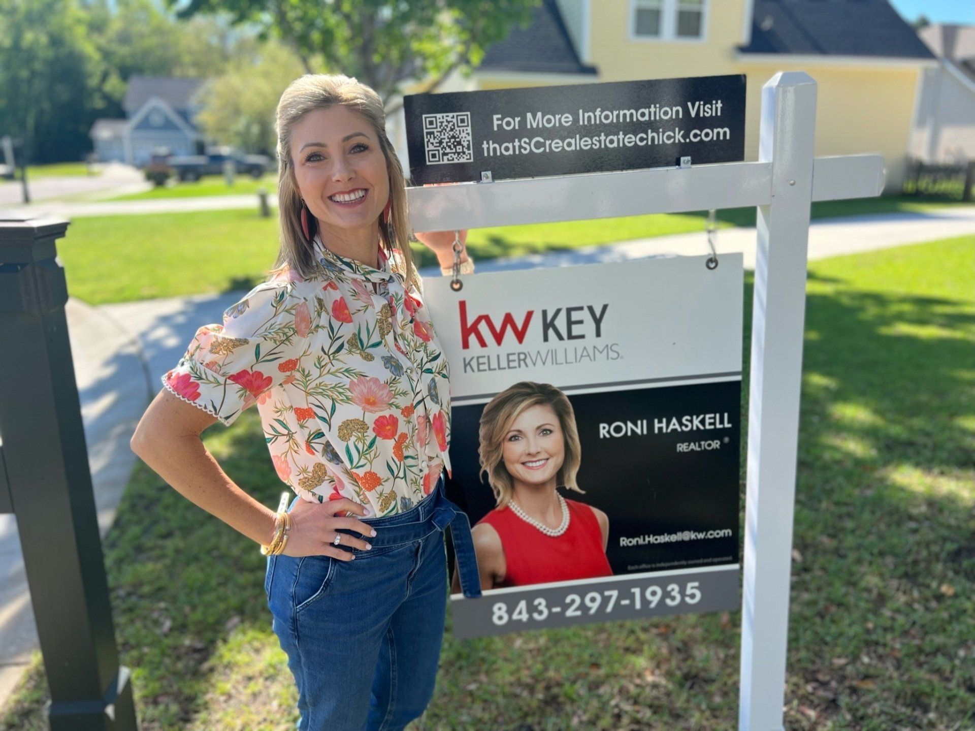 A woman is standing in front of a kw key sign.