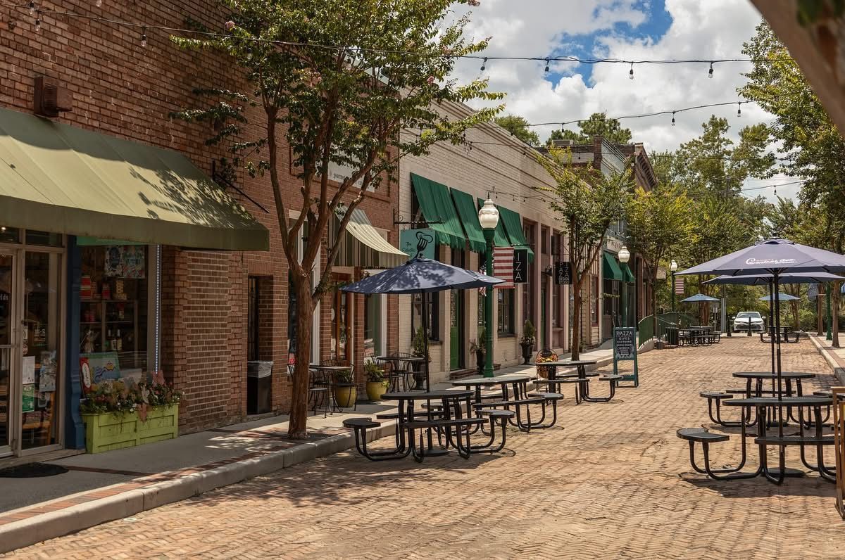 A cobblestone street with tables and umbrellas in Summerville, SC.
