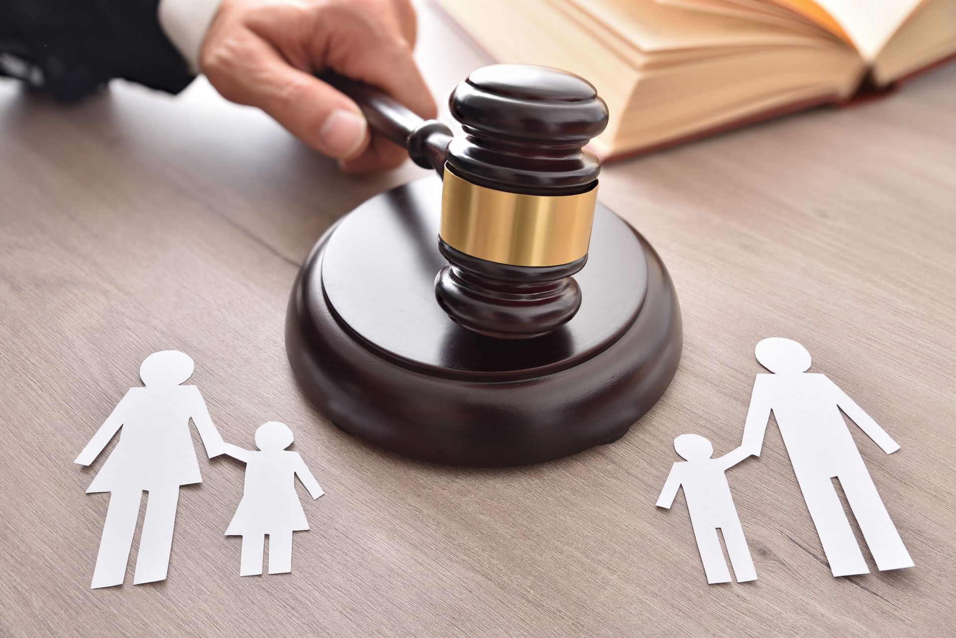 Judge’s gavel beside paper family cutouts on a desk, symbolizing a custody or family law case