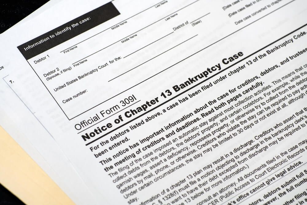 Official form for Chapter 13 bankruptcy, close-up with text and a paper folder in the background.