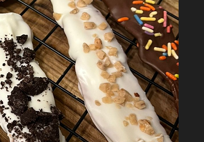 Chocolate-covered pretzel rods: white with crushed cookie, white with toffee bits, and chocolate with sprinkles.
