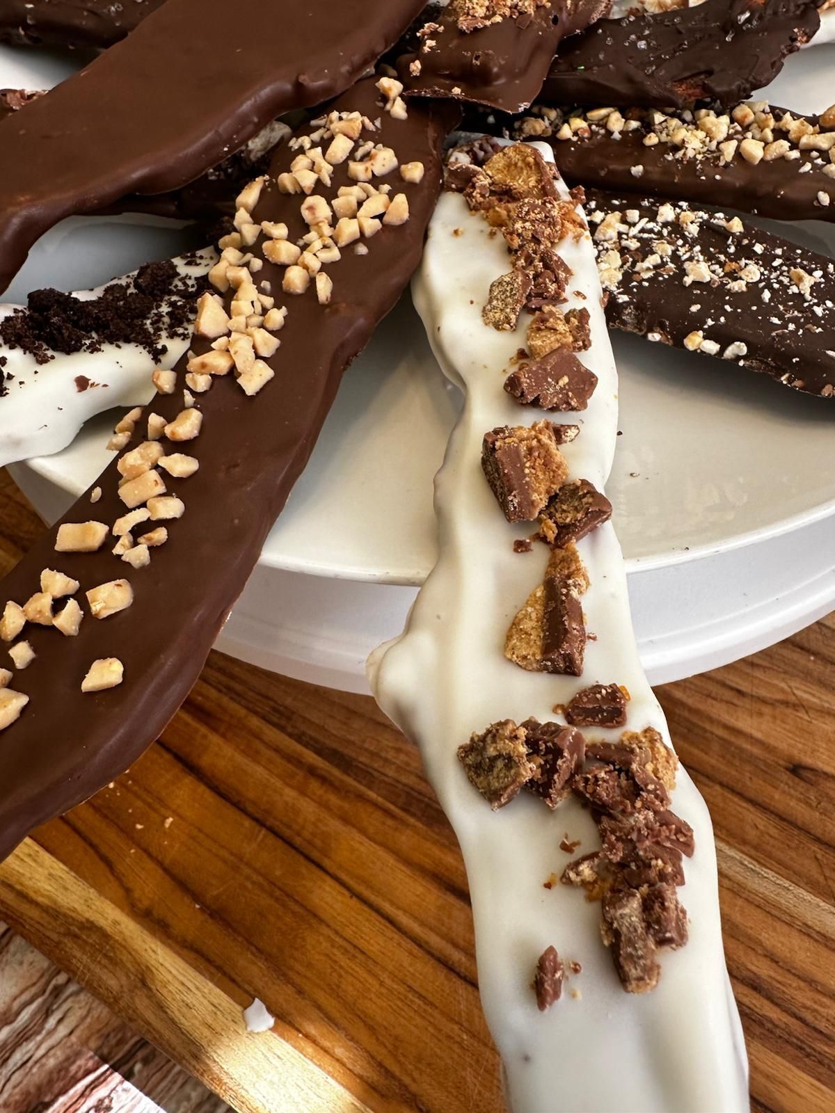 Chocolate-covered frozen bananas, dipped in dark and white chocolate, topped with nuts and candy pieces.