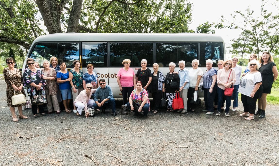 Elderly women standing in front of tour bus