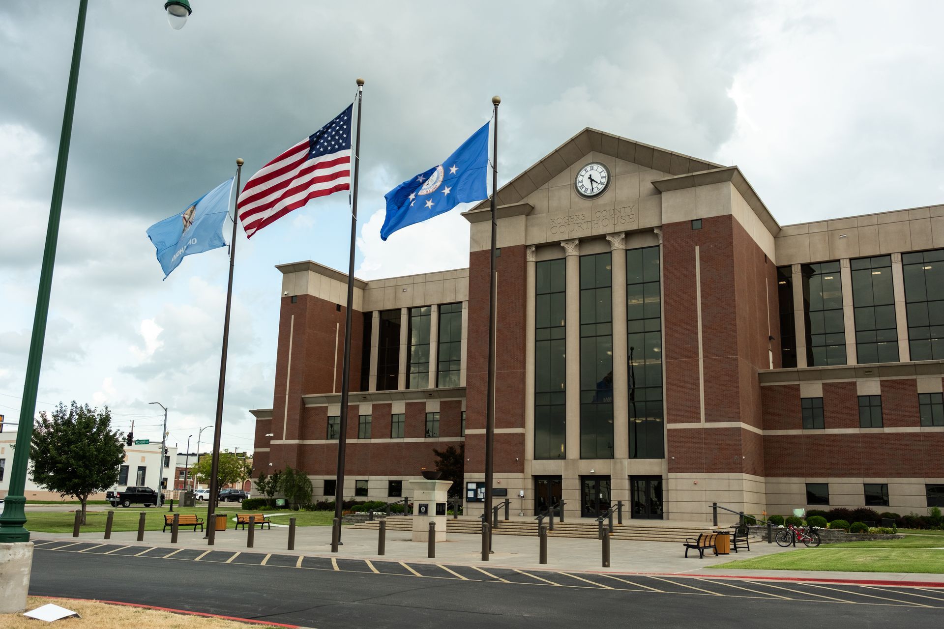Two men in suits shaking hands in a law office, another man smiles in background.