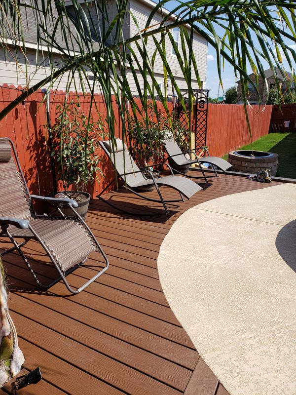 A deck with lawn chairs and a fire pit in the backyard