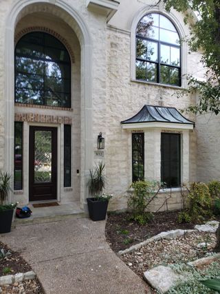 A large brick house with a walkway leading to the front door