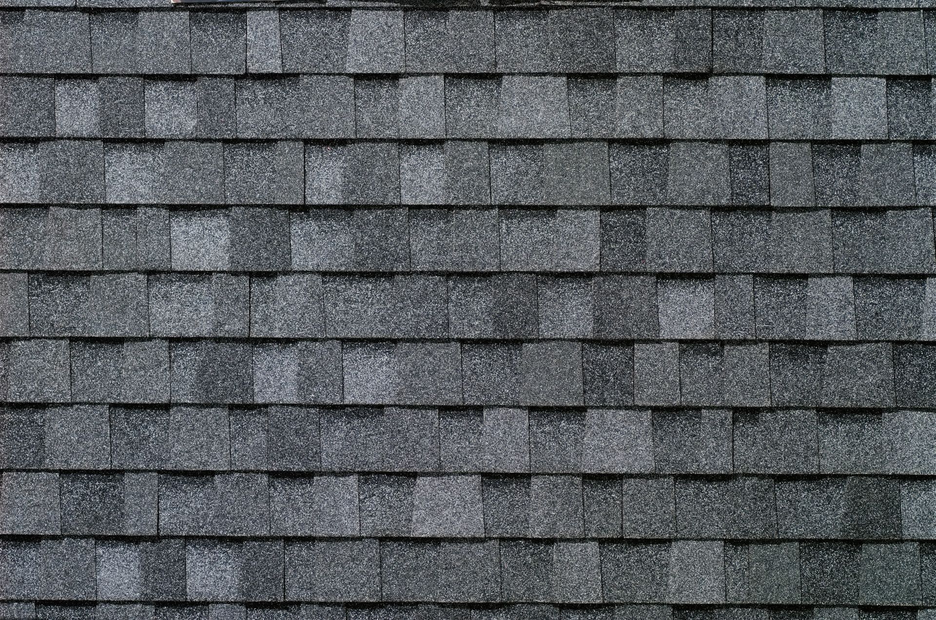 A close up of a row of gray shingles on a roof.