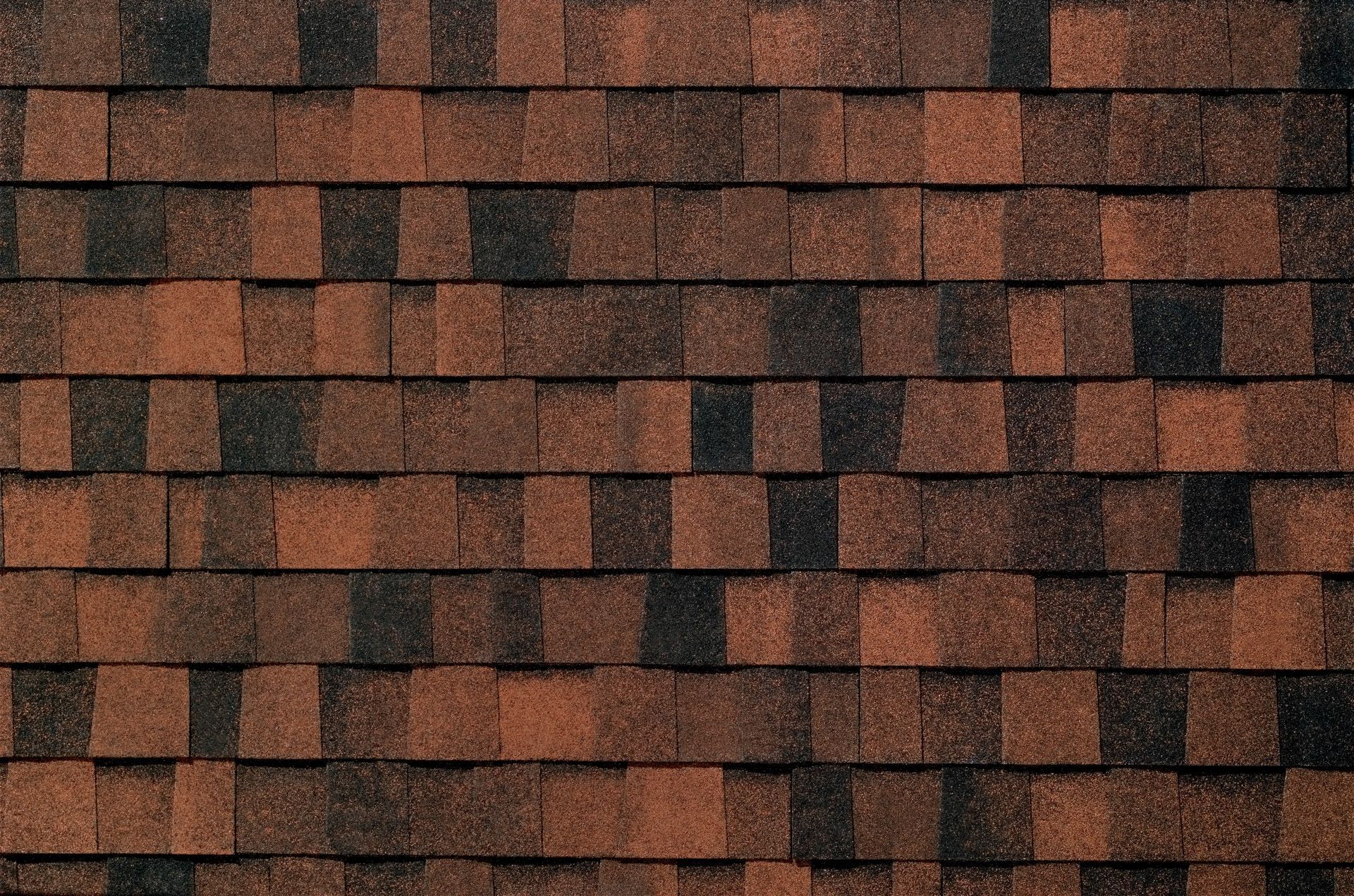 A close up of a roof with brown and black shingles