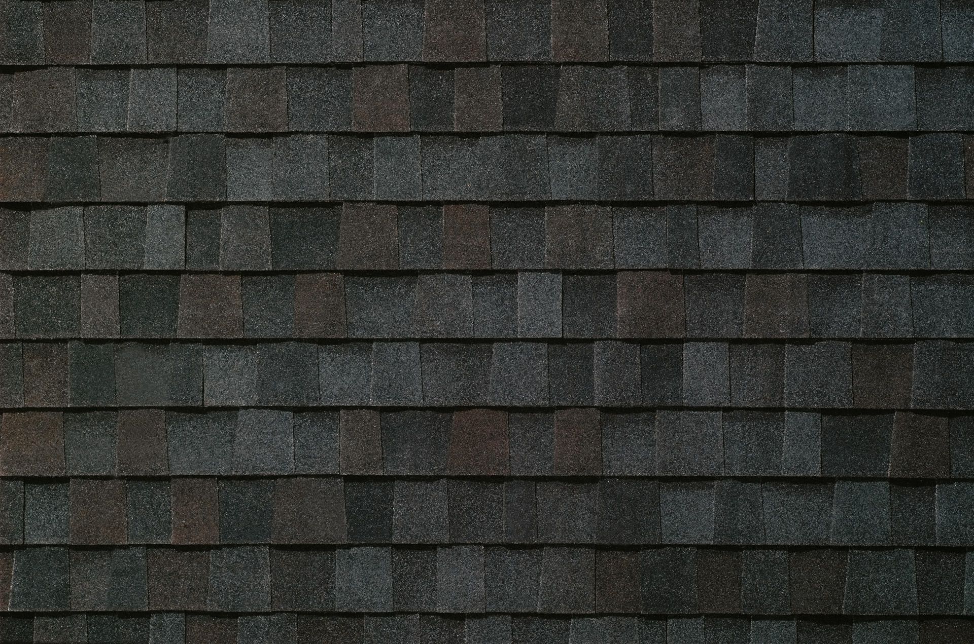 A close up of a roof with black shingles.