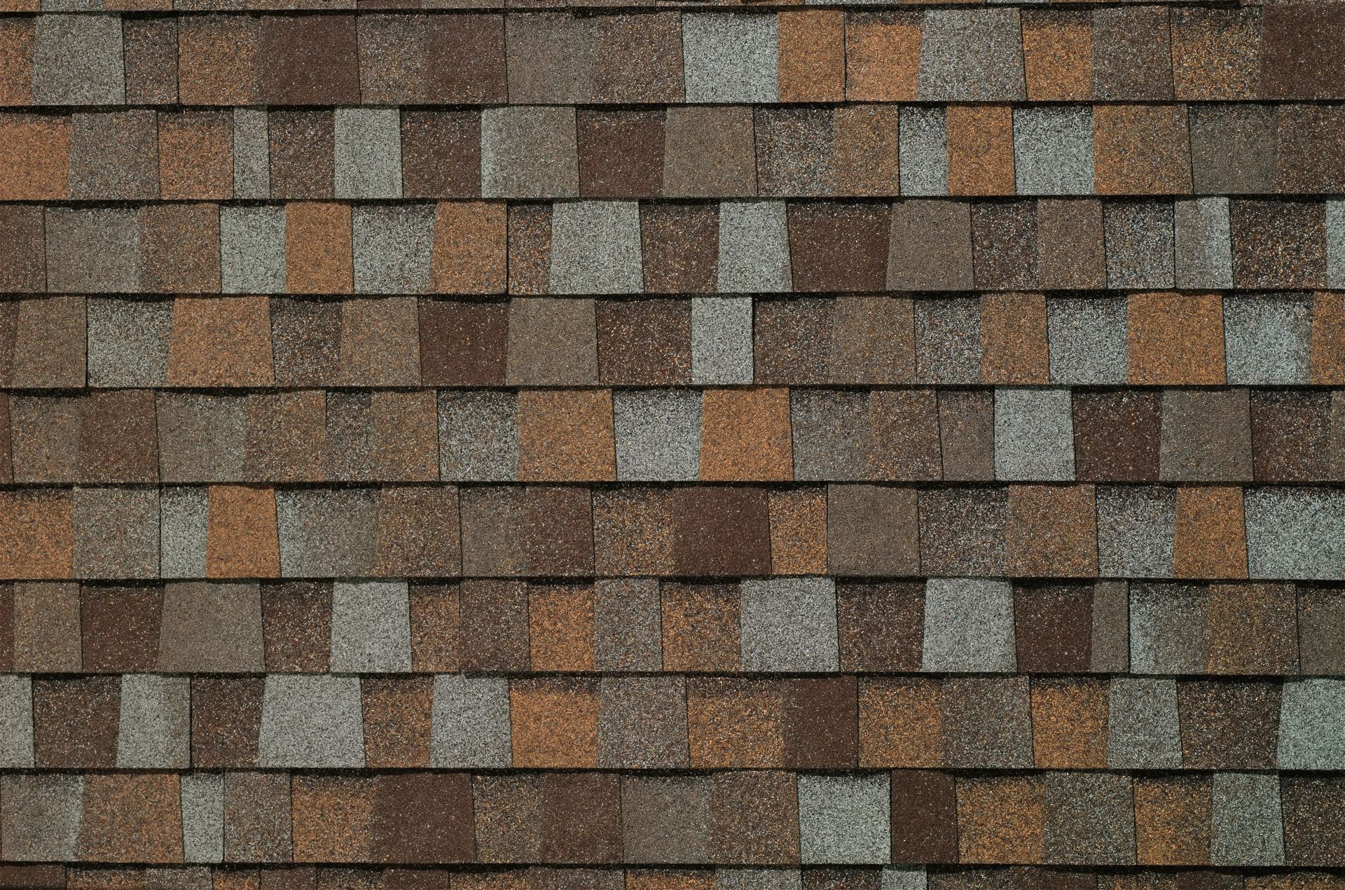 A close up of a roof with brown and gray shingles