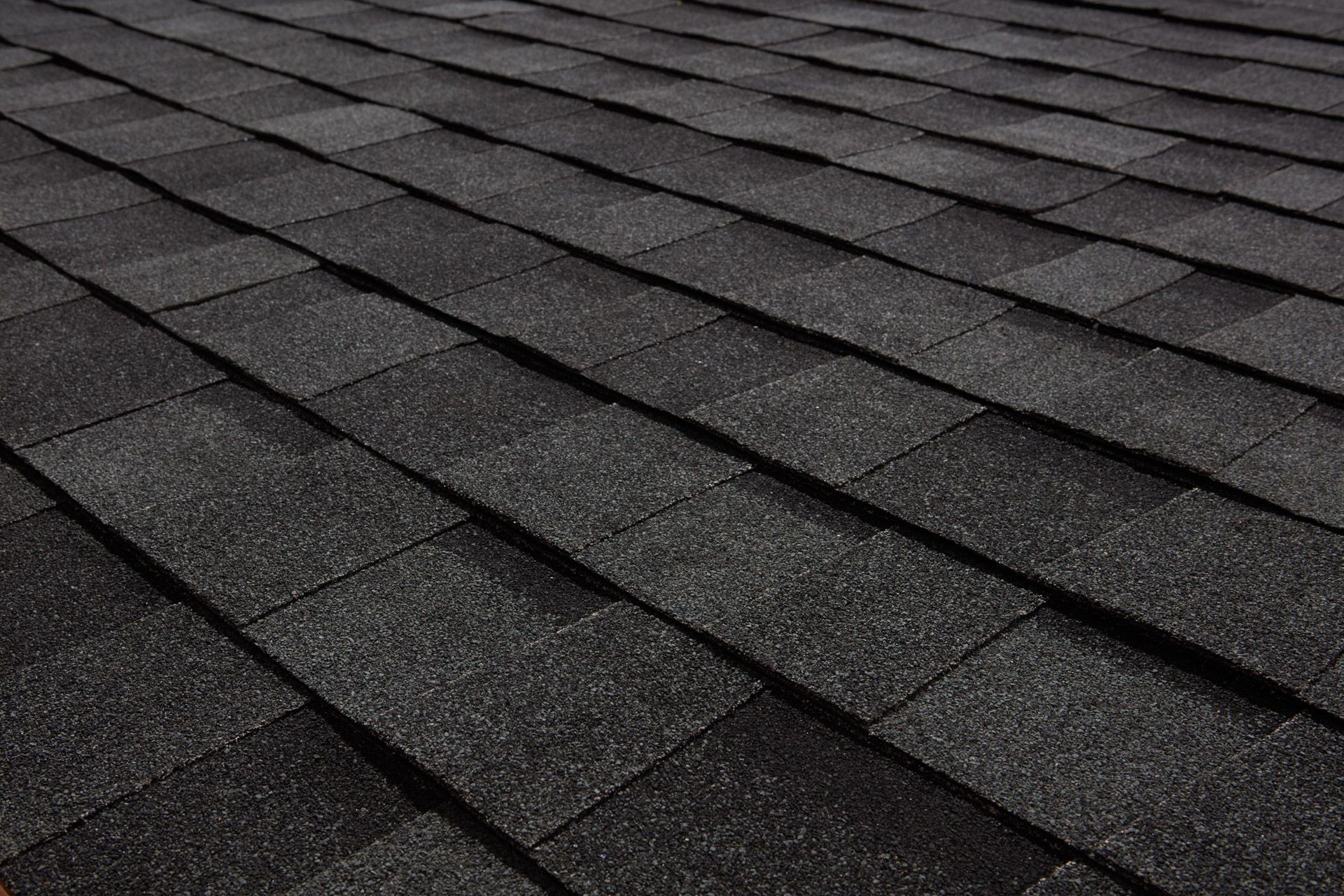A close up of a roof with black shingles.