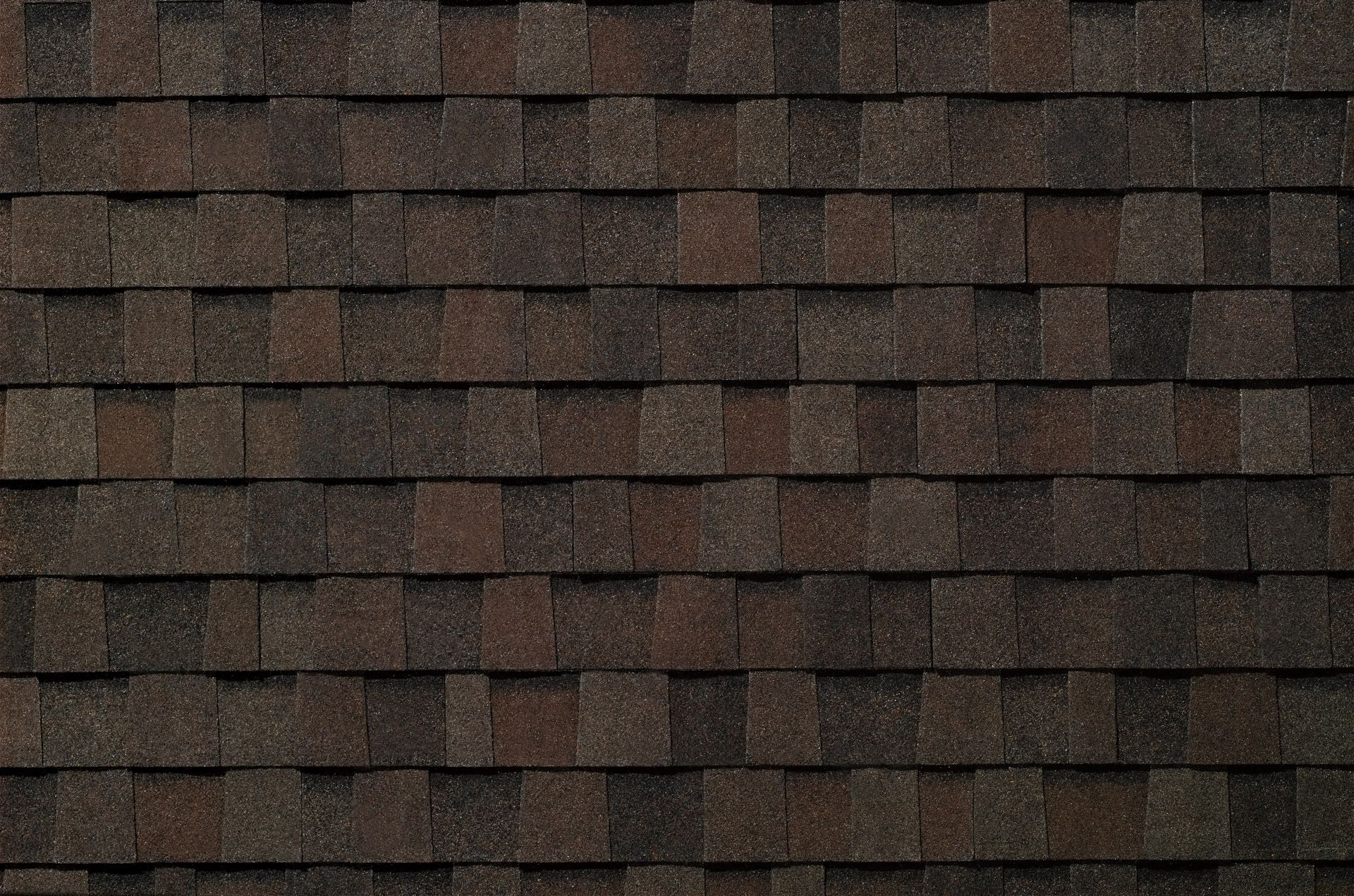 A close up of a roof with brown shingles.