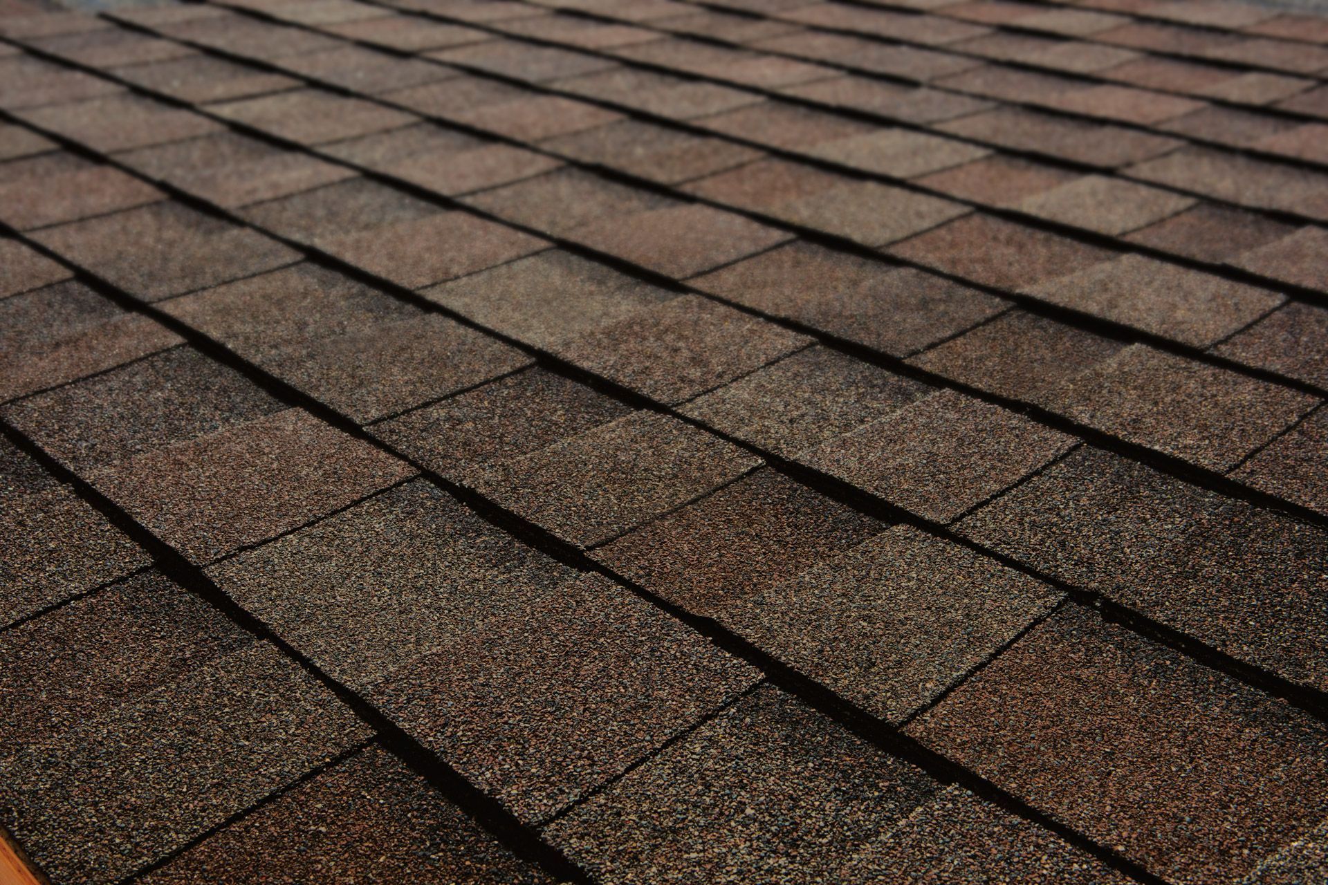 A close up of a roof with brown shingles