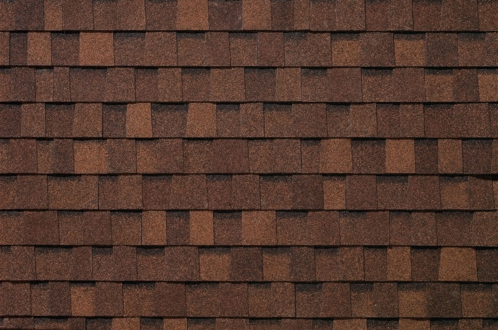 A close up of a roof with brown shingles